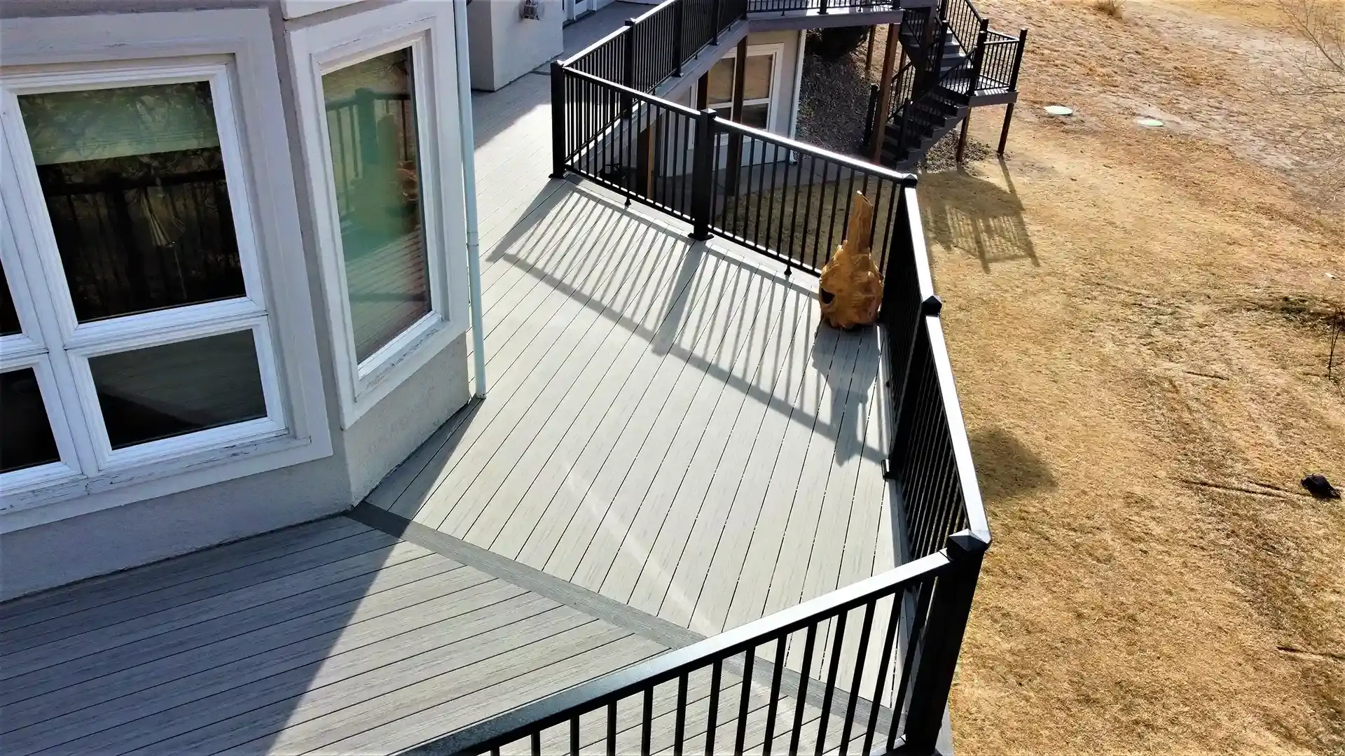 composite deck warranty Elevated gray composite deck with black metal railings